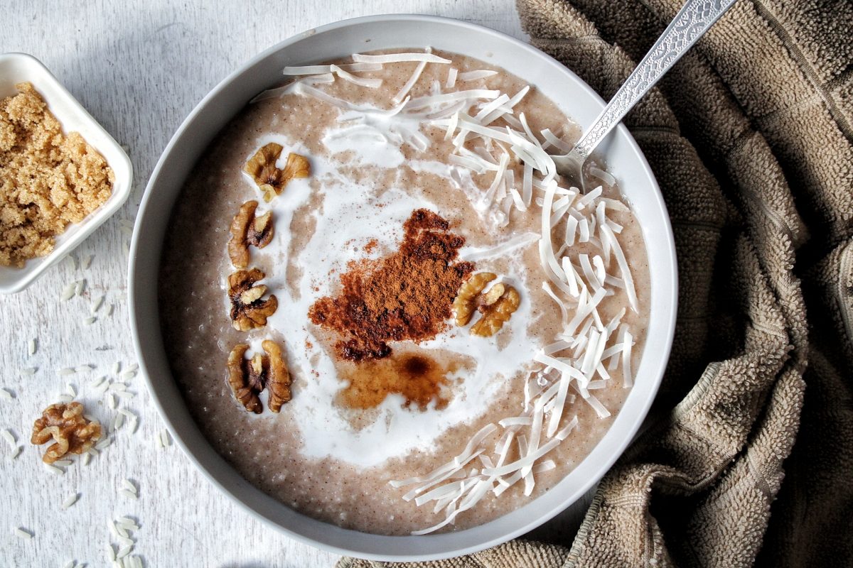 Bowl of rice porridge with cinnamon walnuts, shredded coconut