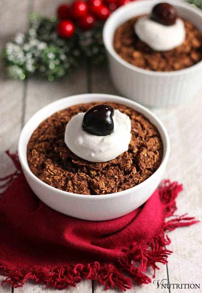 Baked forest cake baked oatmeal in cute bowls topped with coconut whipped cream and fruit