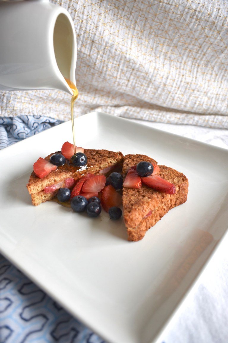 Stuffed french toast topped with fruit and syrup