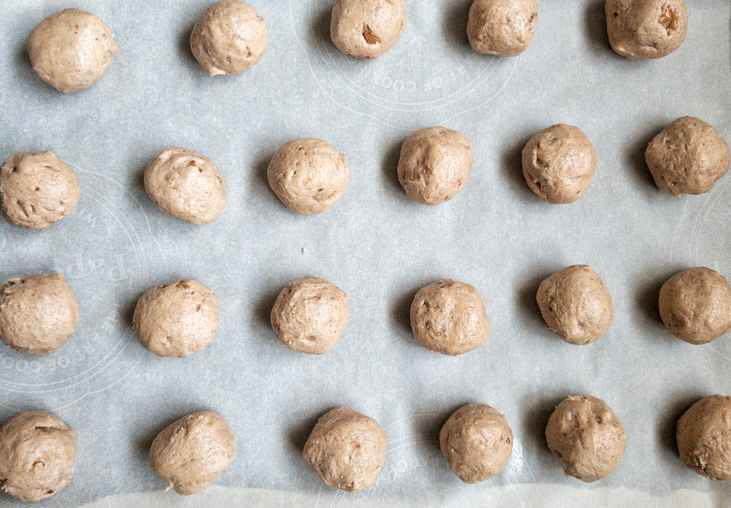 Raw cinnamon-spiced snowball cookie dough on a baking sheet