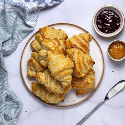 A pile of vegan croissants with a side of jam