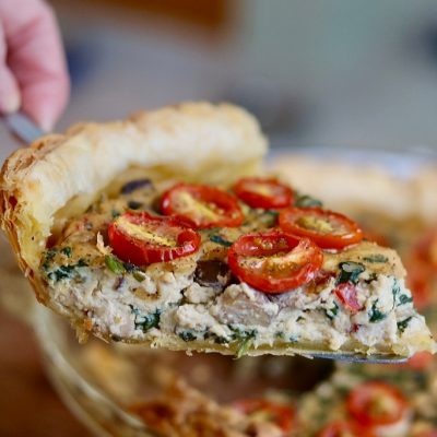 Slice of vegan quiche with mushrooms and spinach