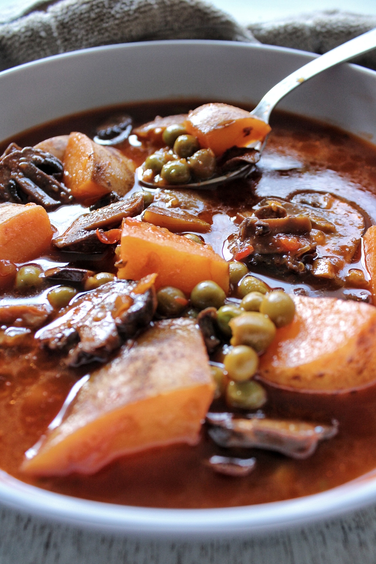 Soup close-up with potatoes, peas, and mushrooms 