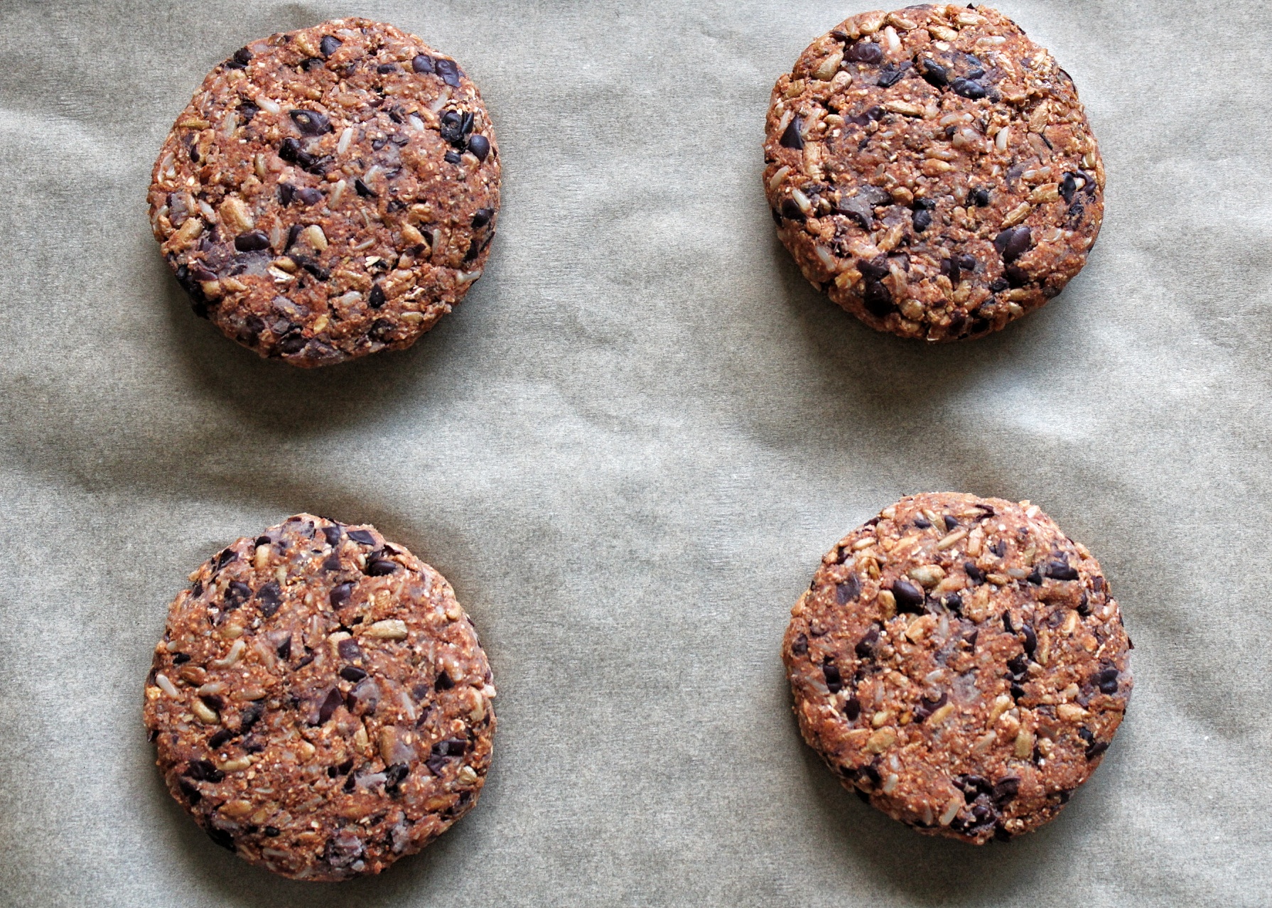 Uncooked veggie burgers on a baking sheet lined with parchment paper. 