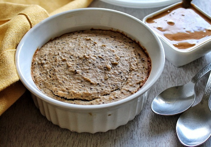 Baked oats in a oven-safe bowl with a side of natural peanut butter 