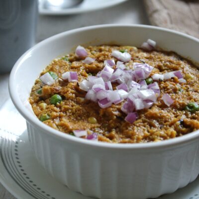 Bowl of vegan, creamy savory oatmeal with Indian spices and flavors.