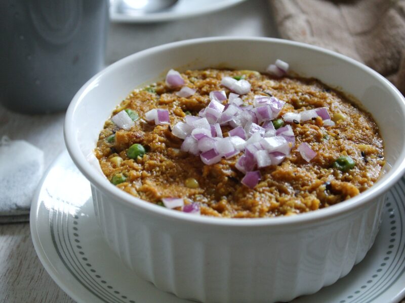 Bowl of vegan, creamy savory oatmeal with Indian spices and flavors.