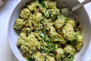 Gnocchi pasta dumplings with pesto and creamy cashew sauce and spinach