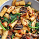 One-pot rigatoni pasta in a bowl with mushrooms, spinach, red chili flakes.