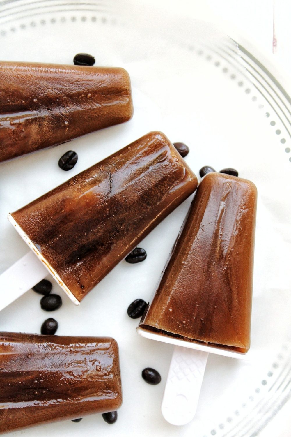 Coffee popsicles with whole beans on a plate 