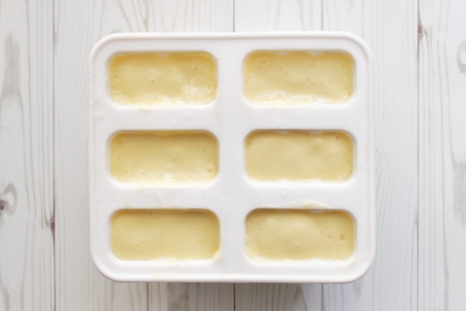 Blended mango, coconut milk, and water in silicone popsicle molds.