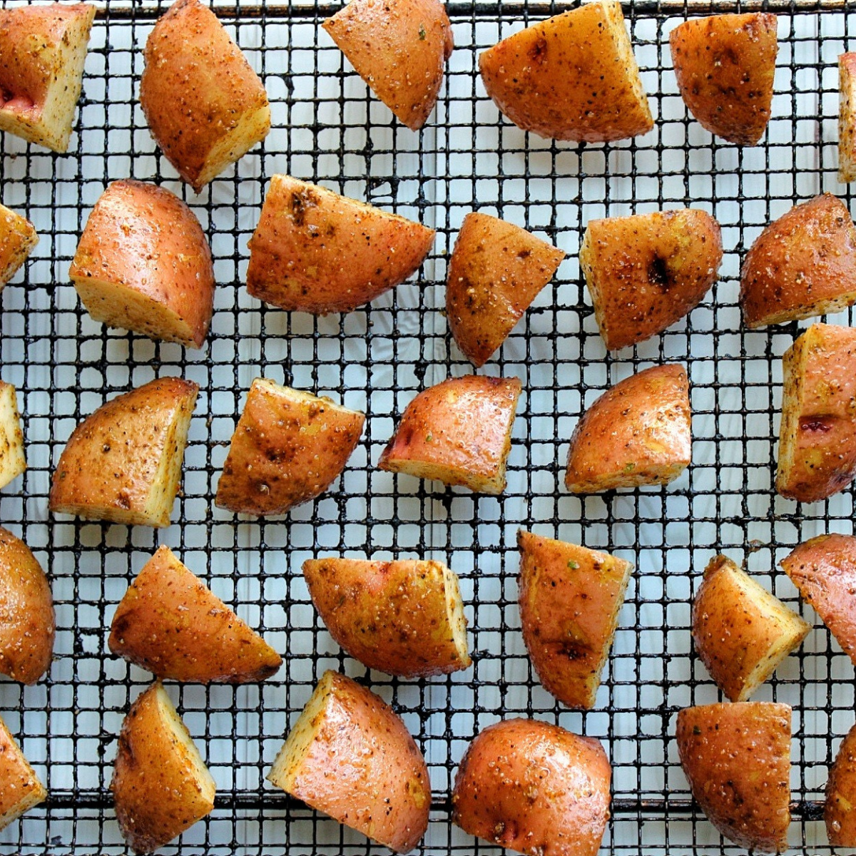 Chopped red potatoes arranged on an air fryer tray