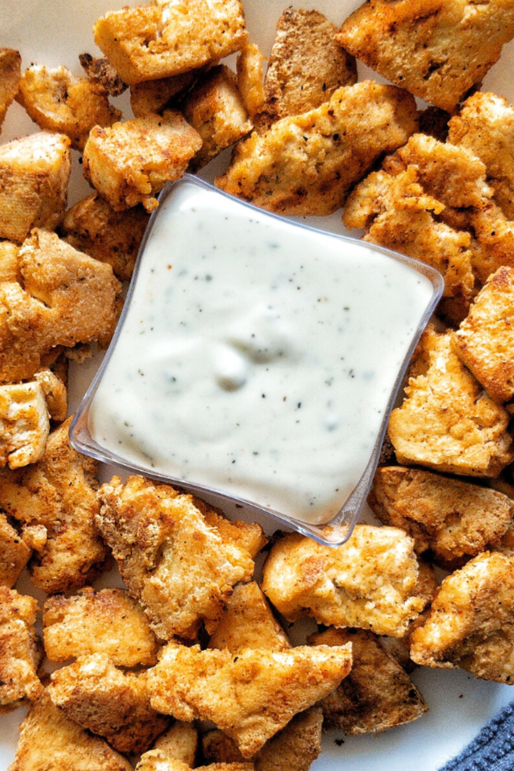 Tofu chicken on a plate with a white dipping sauce. 
