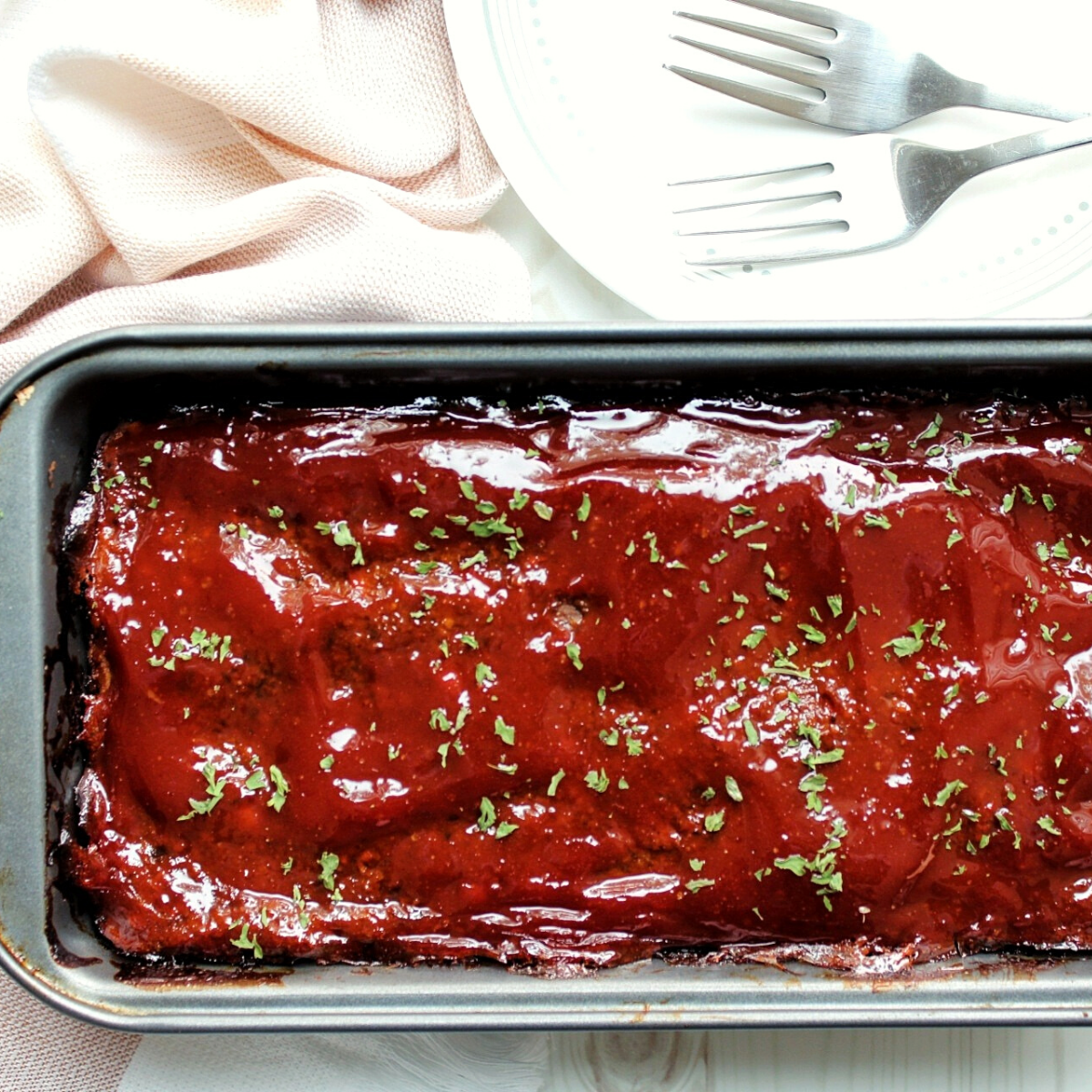 Close-up mushroom lentil loaf in a loaf pan. Topped with dried parsley. 