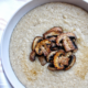 Creamy oat bran porridge topped with mushrooms in a gray bowl.