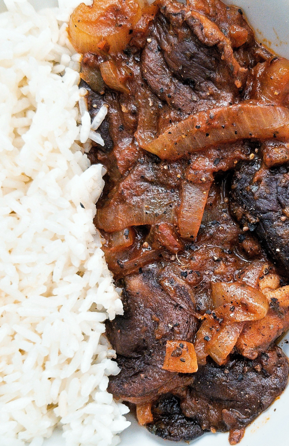 Stewed mushrooms with onion with a side of rice.