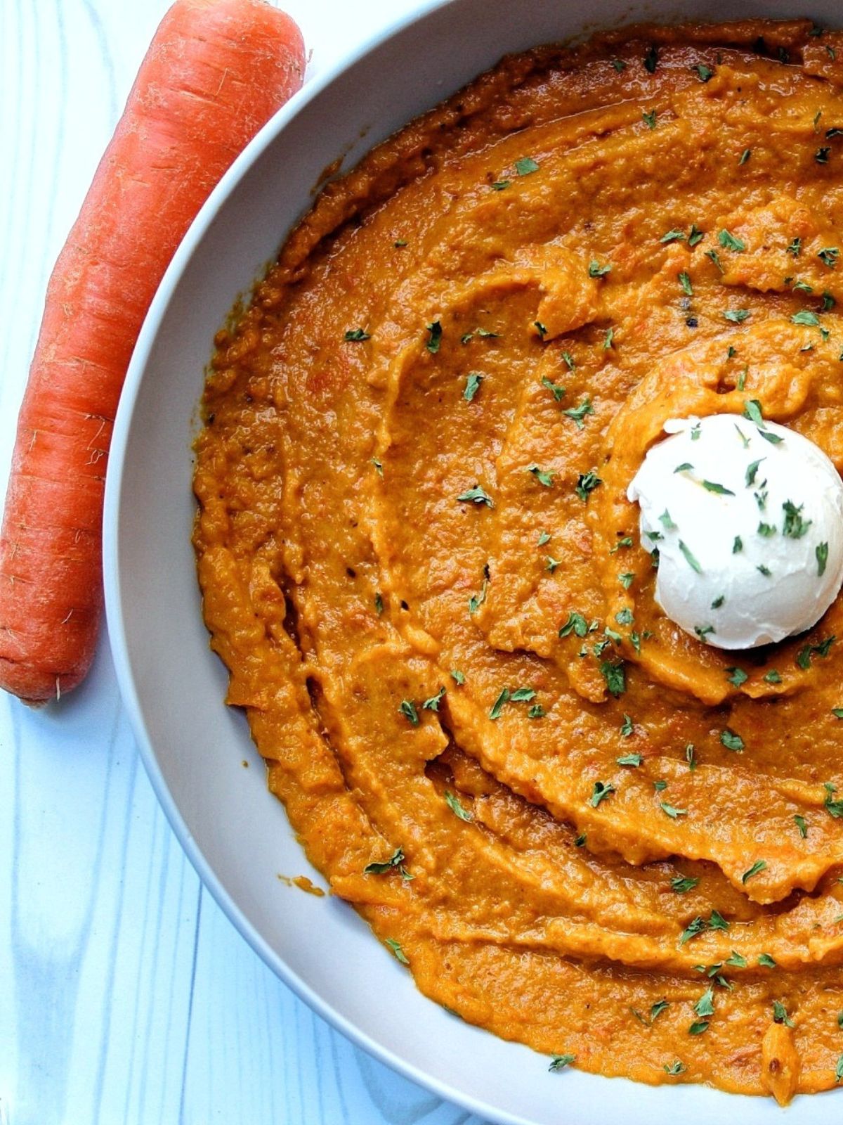 Bowl of mashed carrots with a dolloop of vegan butter. 