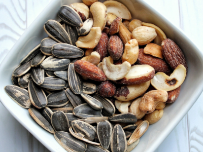 Small white bowl with sunflower seeds and mixed nuts