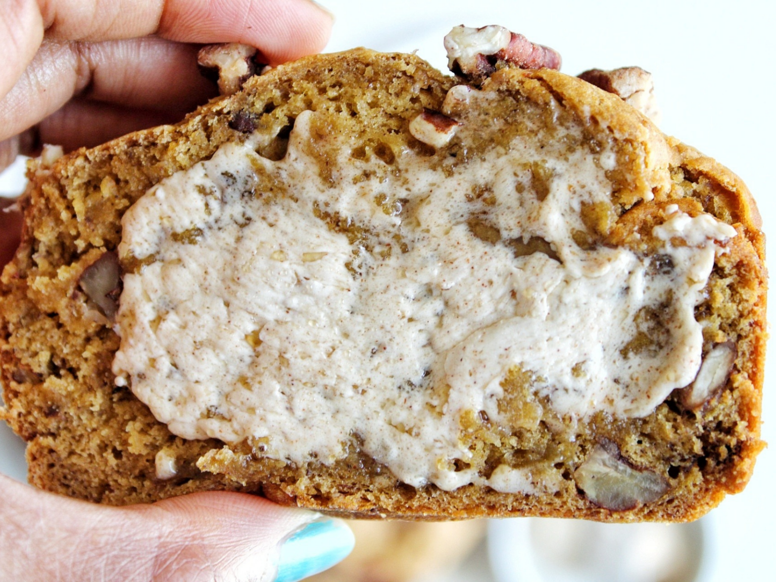 Close-up of pumpkin banana bread slice with a cinnamon butter spread.