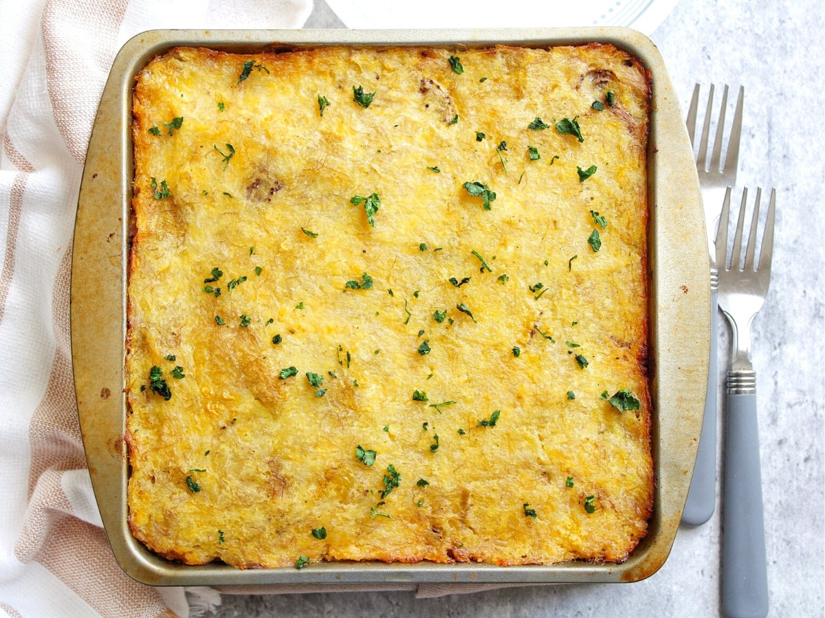 Cooked vegan lentil pastelon in an oven-safe dish, garnished with chopped cilantro.