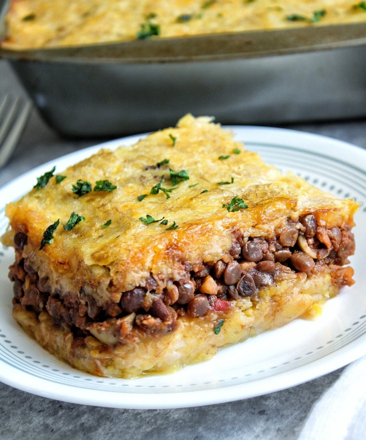 A slice of vegetarian lentil Pastelón with cilantro.