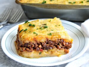 Slice of vegan lentil pastelon topped with chopped cilantro