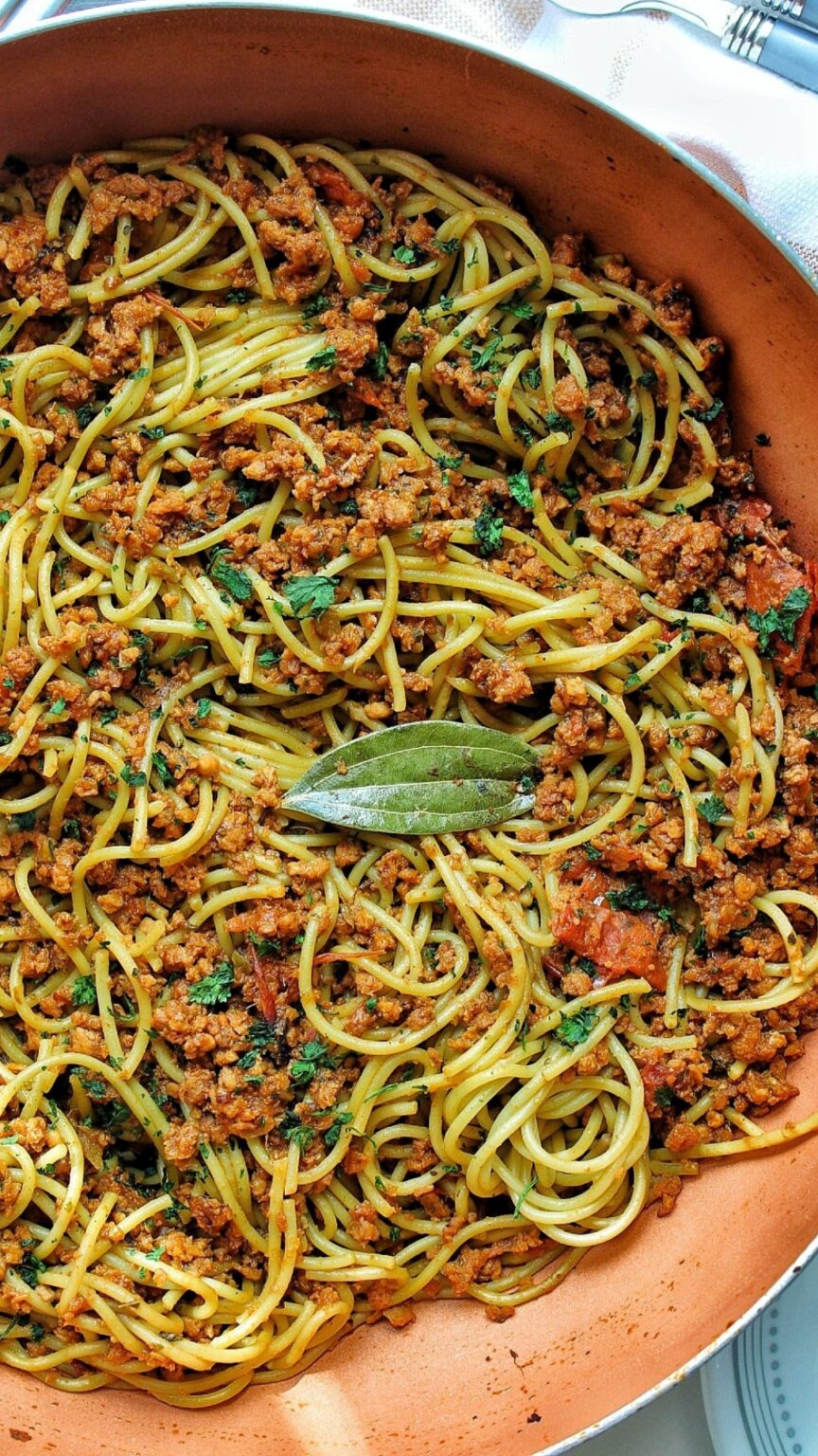 Puerto RIcan spaghetti with bay leaves in a deep pan/wok. 