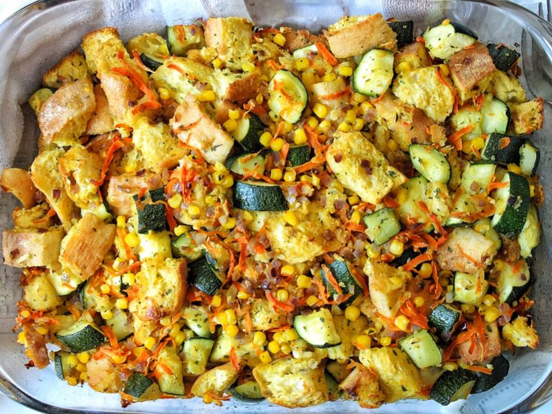 Zucchini stuffing casserole with carrots, corn, and stale bread in a casserole dish.
