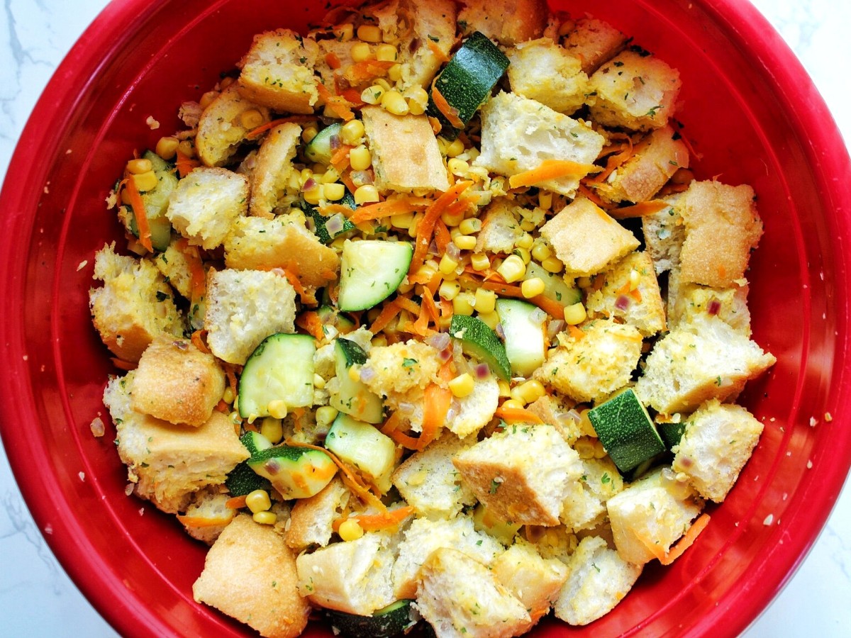 Zucchini stuffing casserole ingredients in a large, red mixing bowl. 