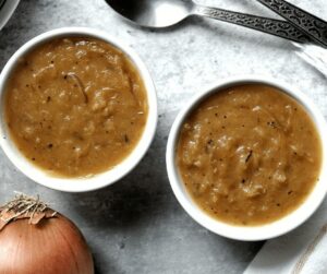 Onion gravy in two white serving bowls.