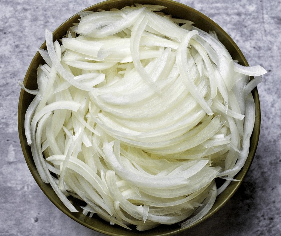 A bowl of thinly sliced onions. 