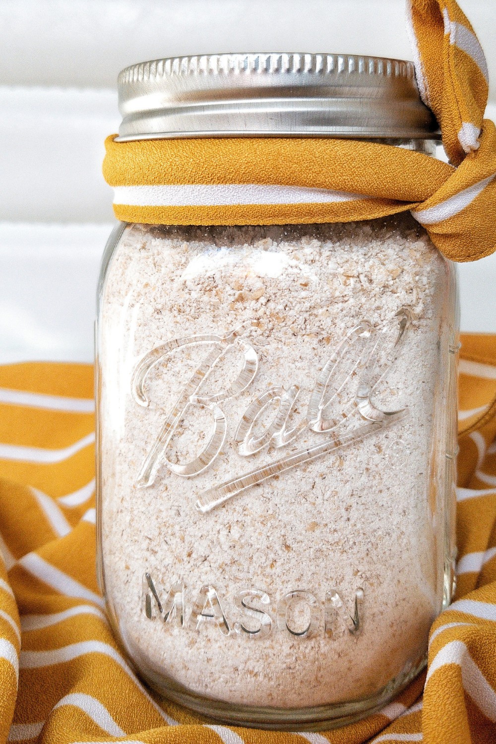 Blended oats into a flour in a glass jar with a yellow ribbon. 