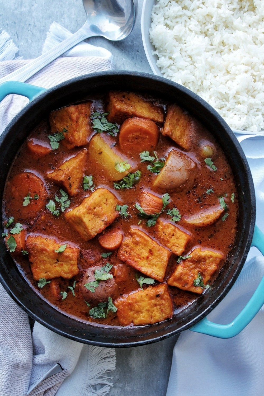 Puerto Rican tofu stew in a pot with a side of rice.