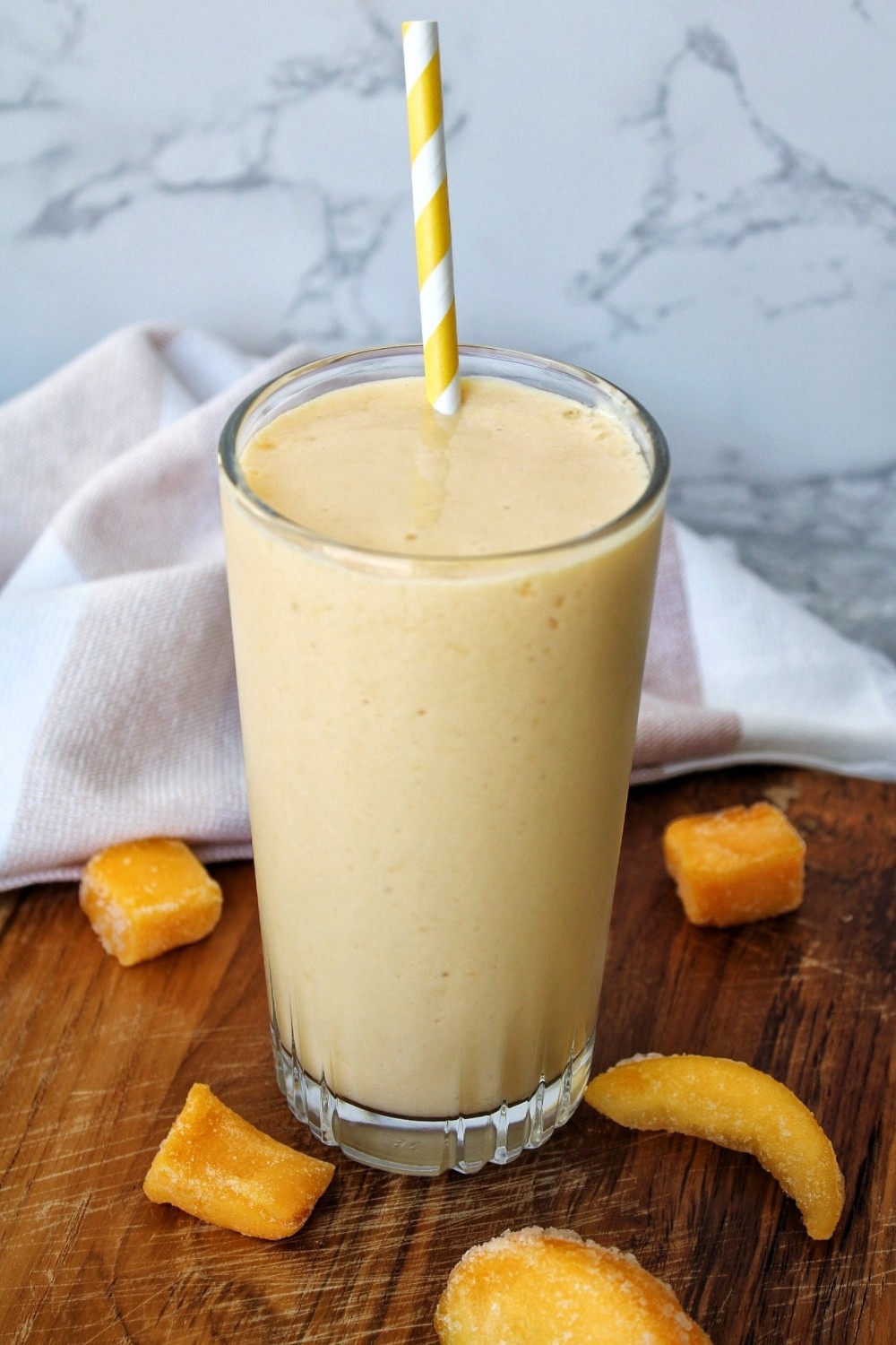 Fruit smoothie in a glass cup with a straw. 