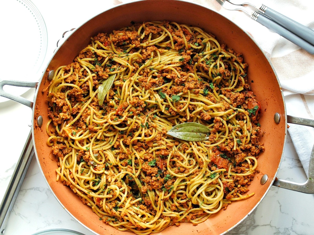 Homemade Puerto Rican-style spaghetti with vegan ground beef, herbs, and bay leaves. I an a large wok. 