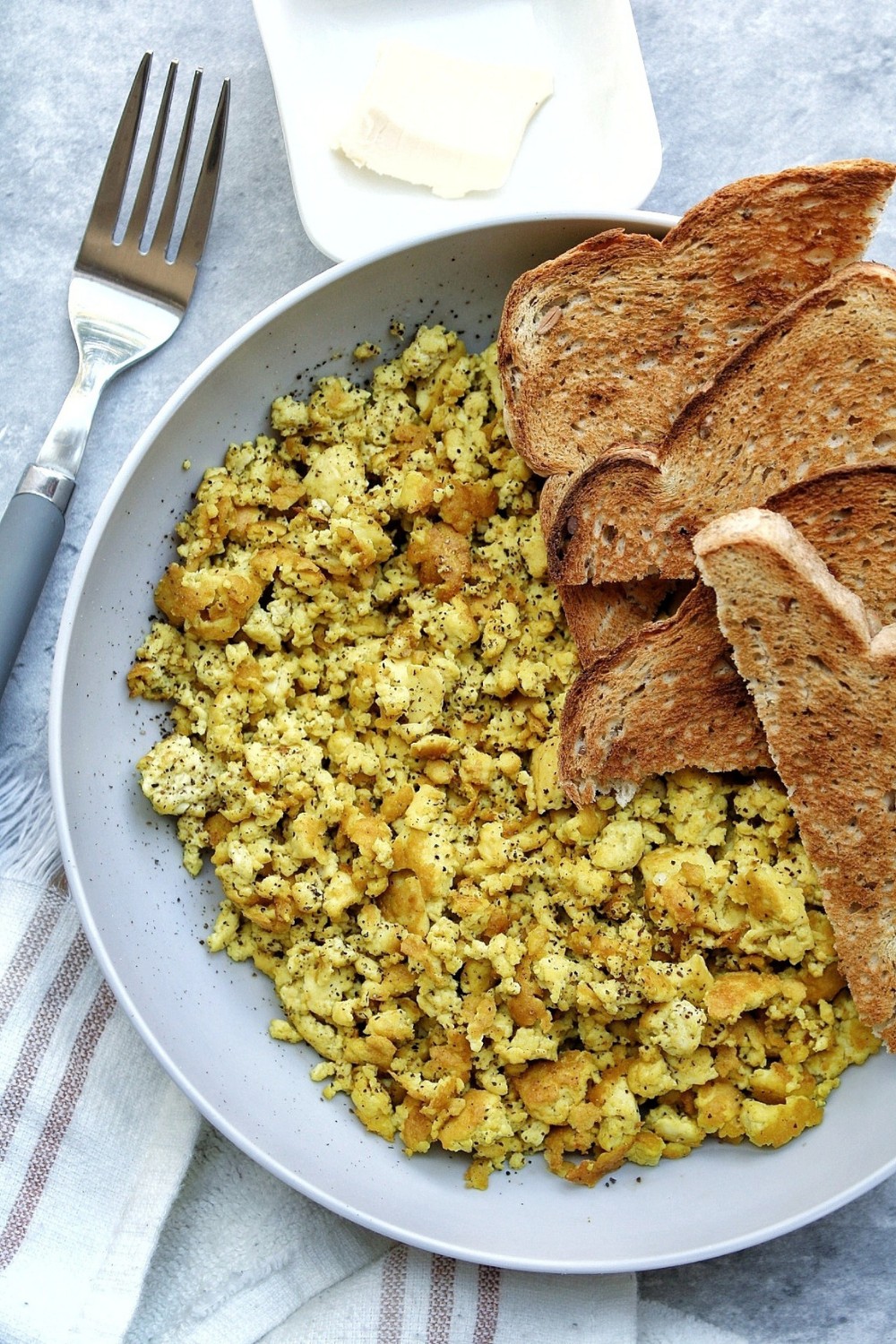 Tofu scramble with black pepper with a side of toasted bread. 