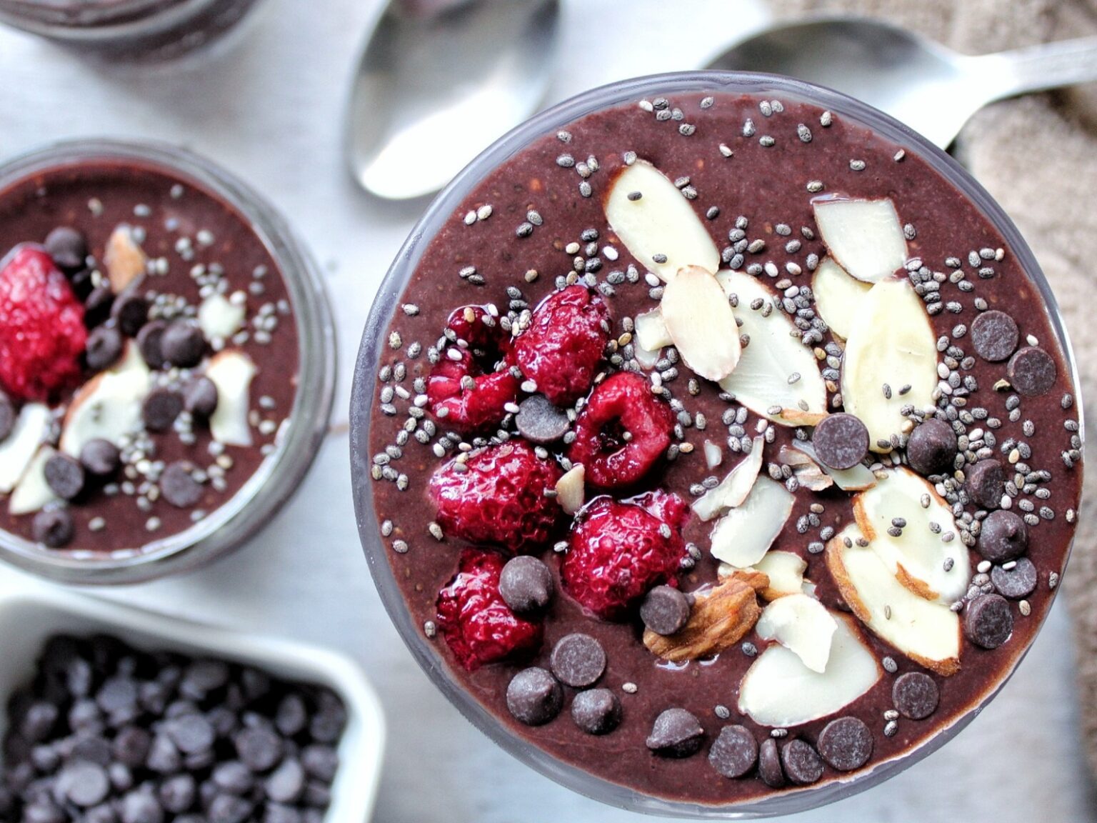 Chocolate chia seed pudding topped with sliced almonds, chia seeds, raspberries, and chocolate chips. 