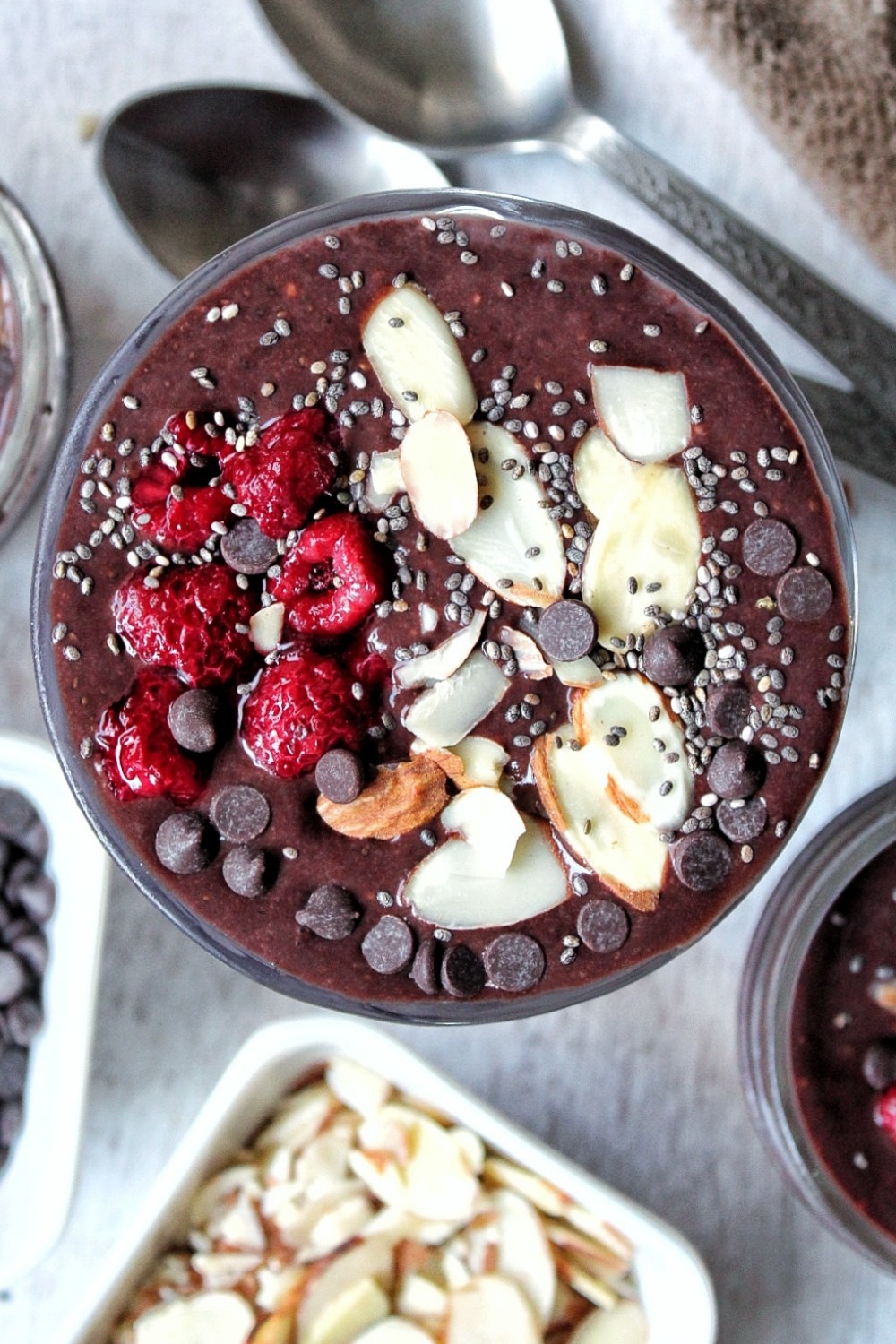 Chocolate chia seed pudding topped with sliced almonds, chia seeds, raspberries, and chocolate chips. 