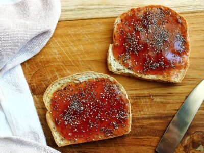 Two pieces of toast topped with fruit jam and chia seeds.