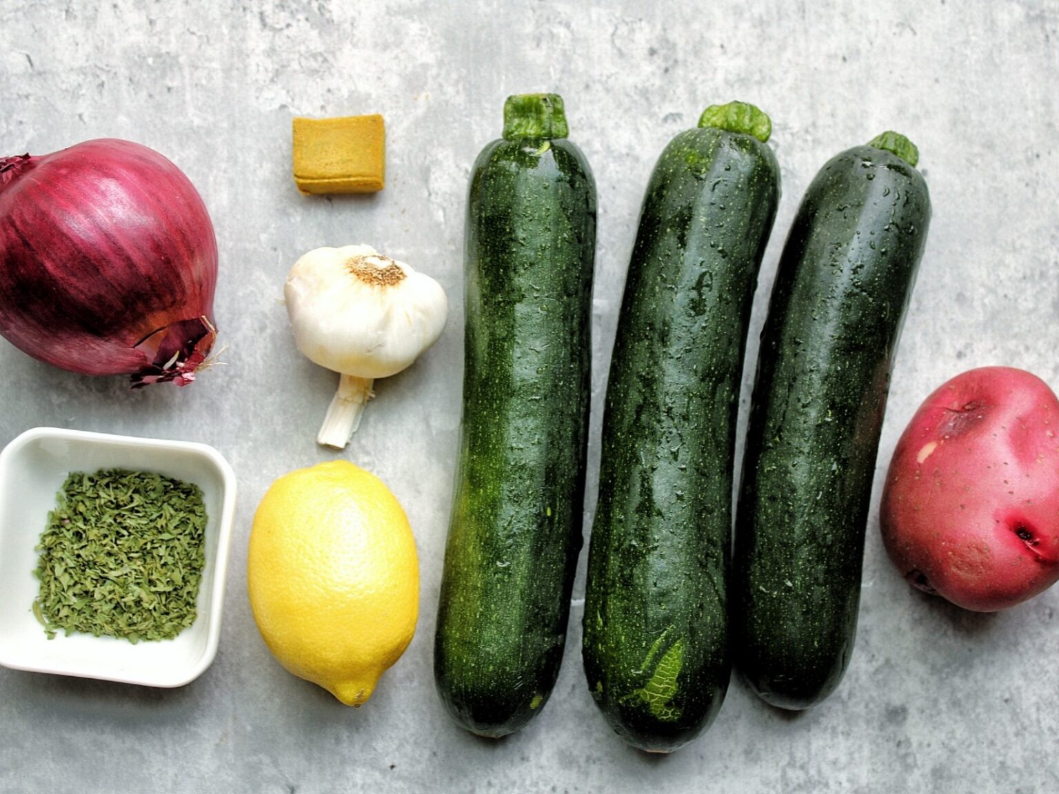 Zucchini soup ingredients (onion, parsley, garlic, lemon, bouillon, zucchini potato).