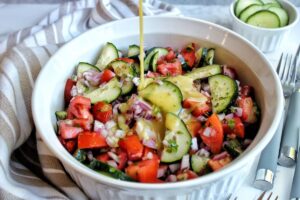 Cucumber tomato onion salad with a pour of homemade apple cide vinaigrette.