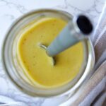 Cucumber tomato onion salad dressing in a mason jar.