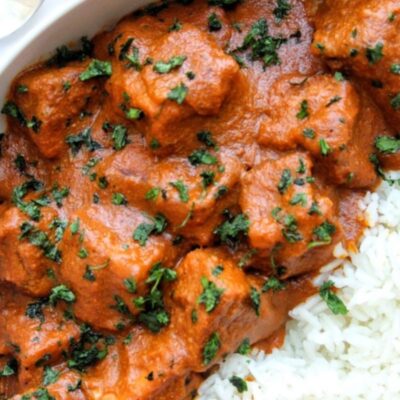 Vegan butter chicken topped with cilantro and served with rice.