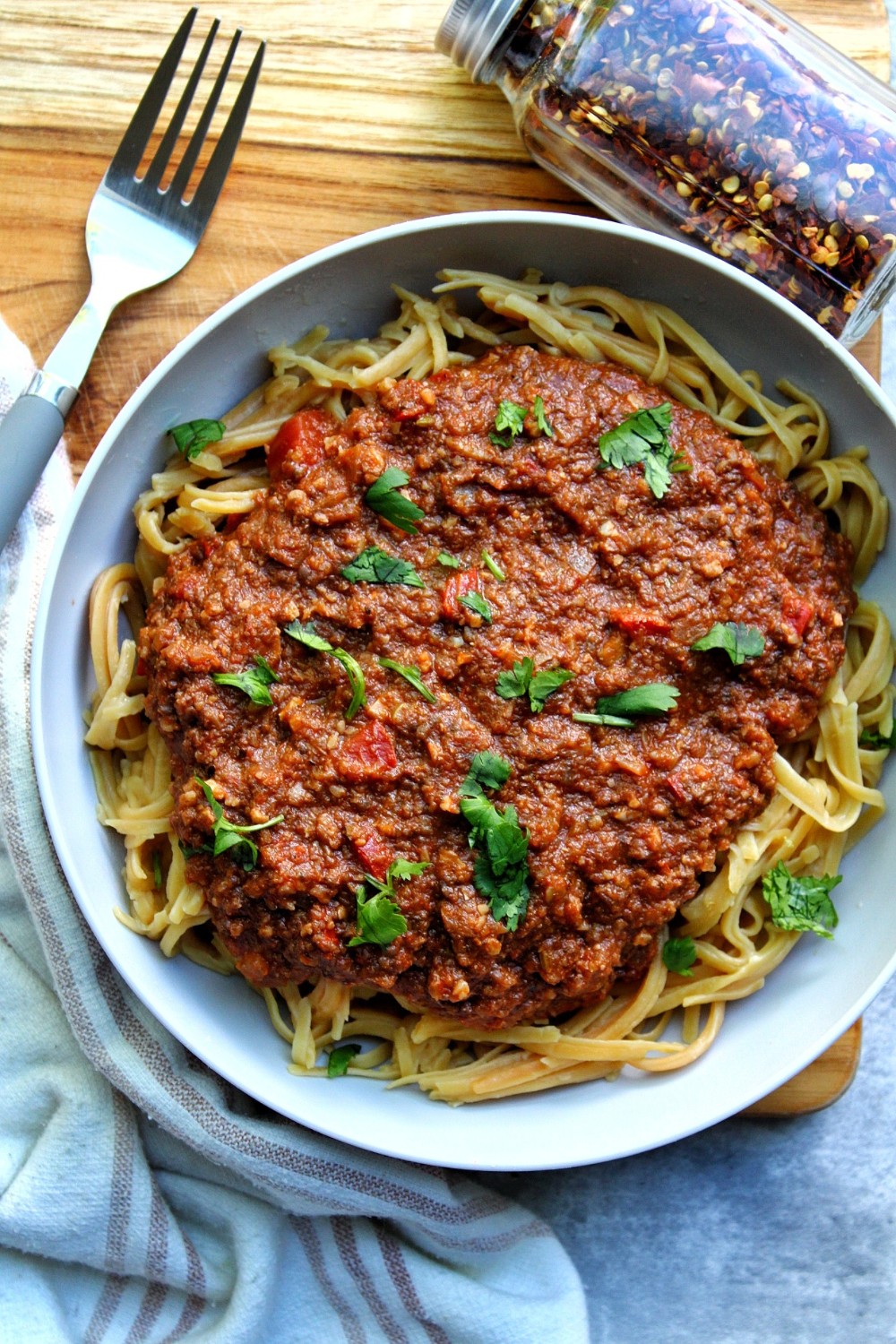 Bowl of meatless bolognese topped with chopped cilantro.