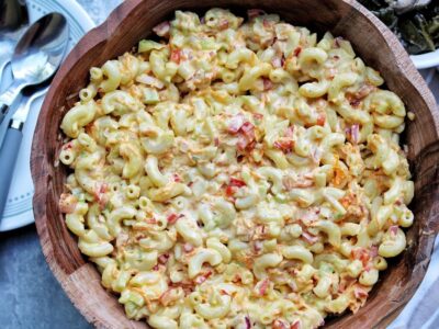 Vegan macaroni pasta salad with bell pepper, onion, and carrots. In a serving bowl.