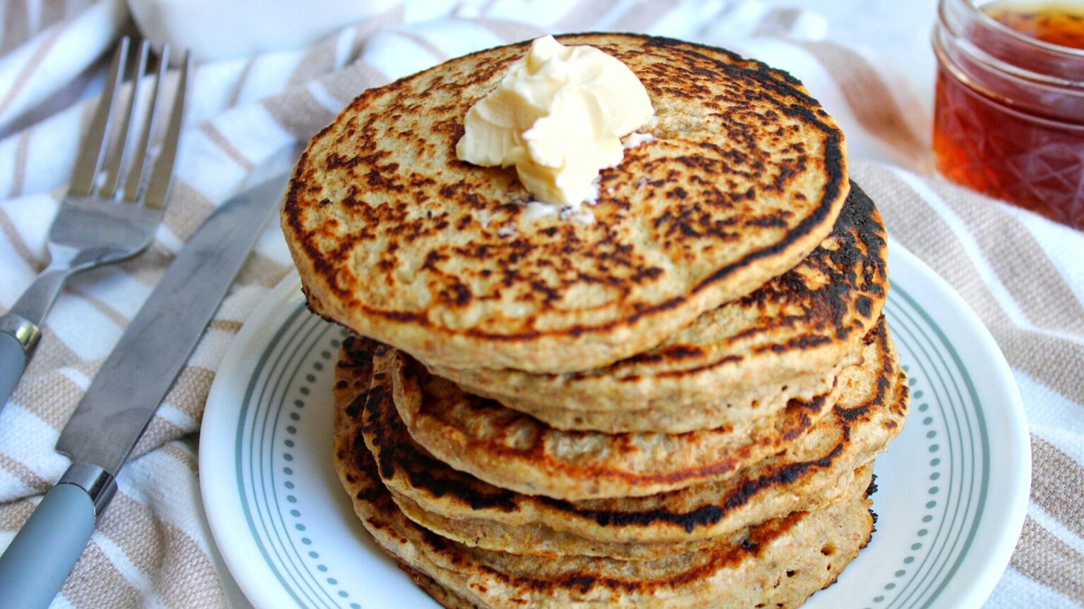 Stack of oat bran pancakes with a pat of butter.