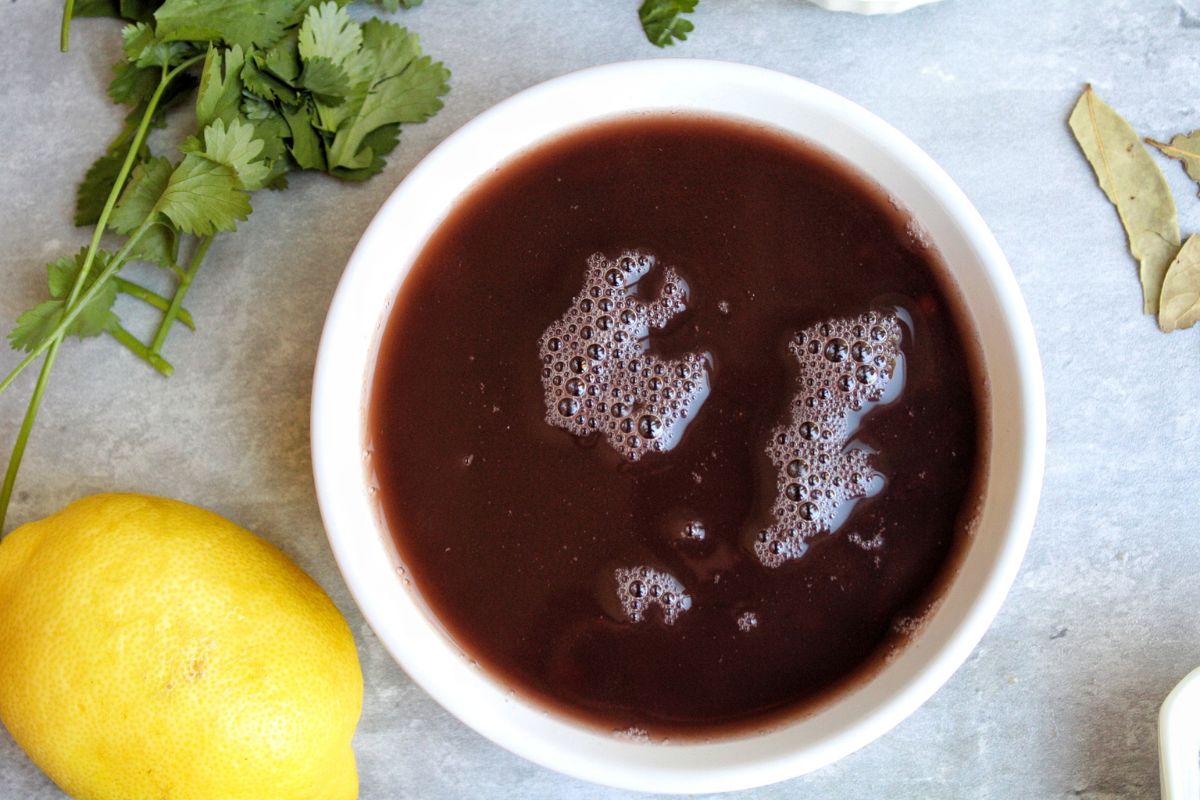 White bowl with canned, uncooked black beans. 