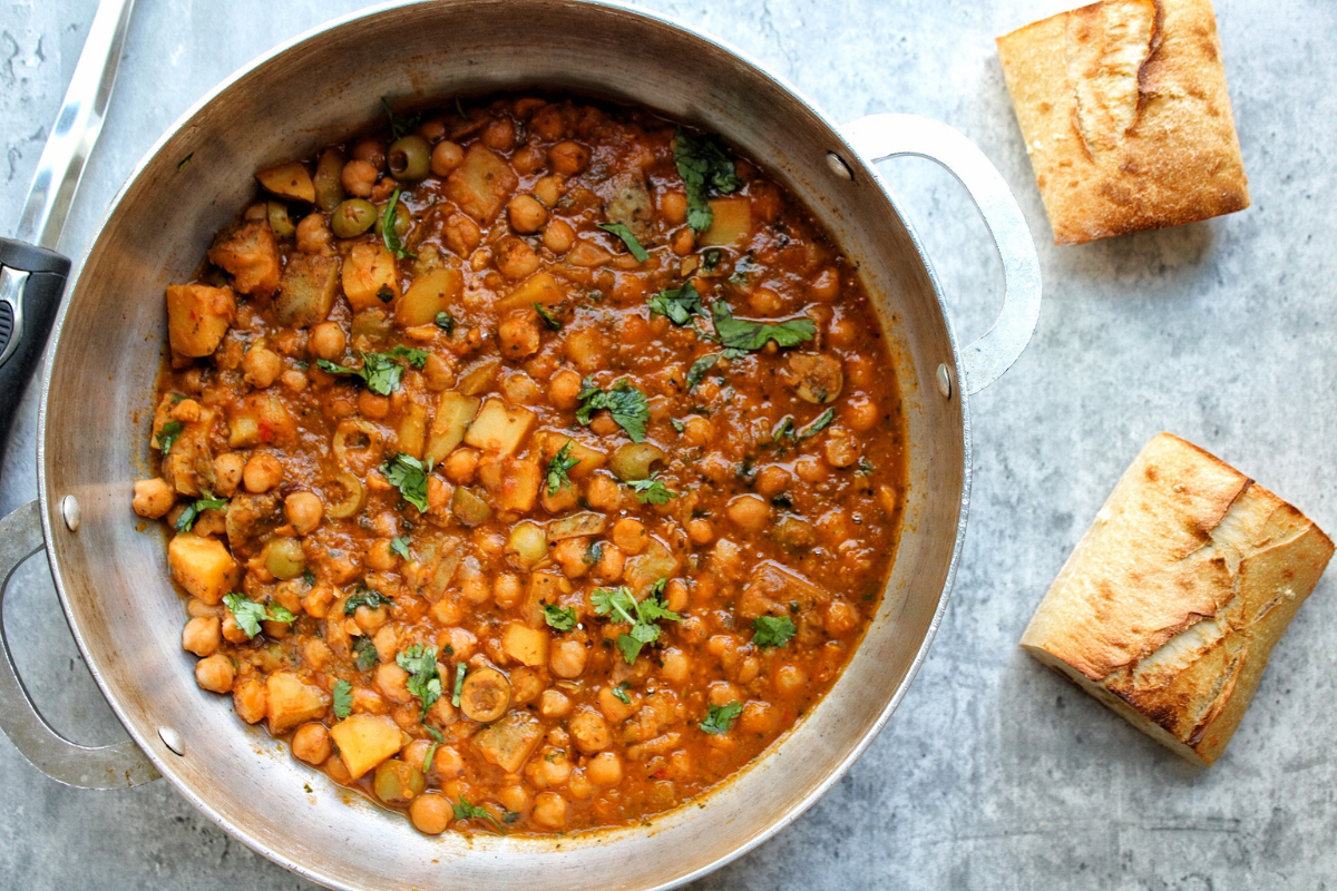 Pot of chickpea stew topped with chopped cilantro. 