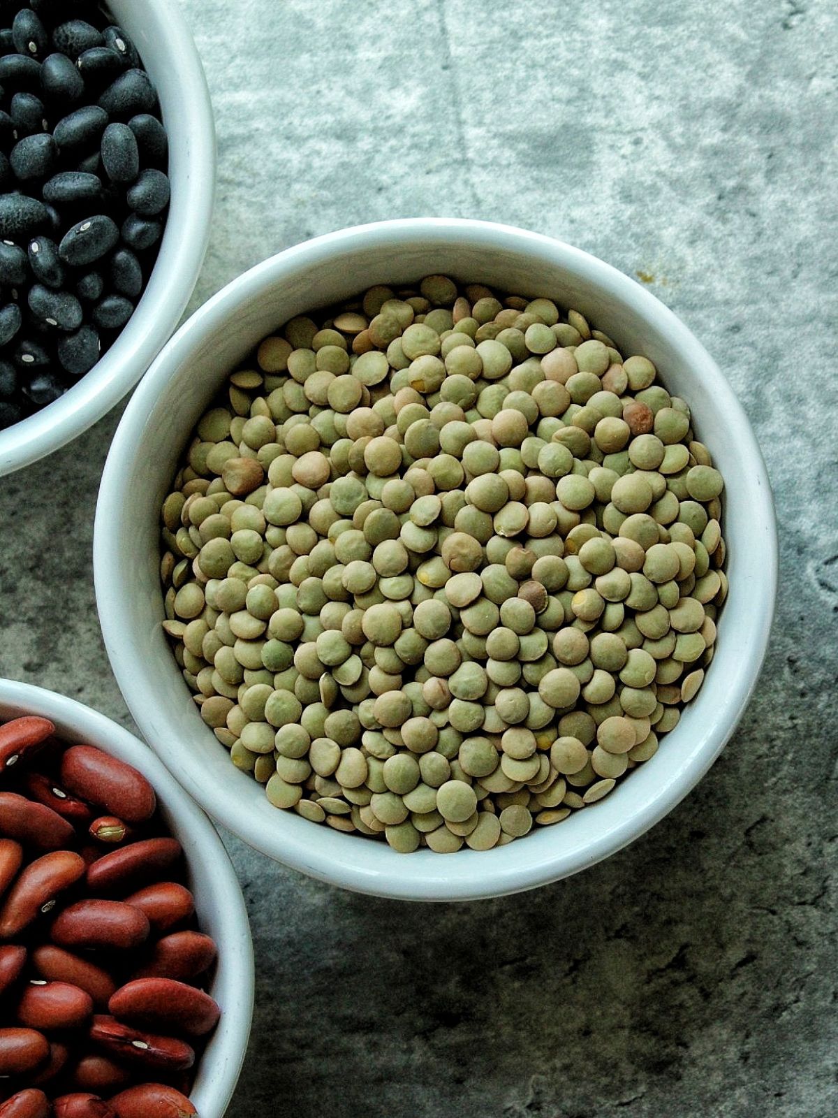 Green lentils in a white bowl. 