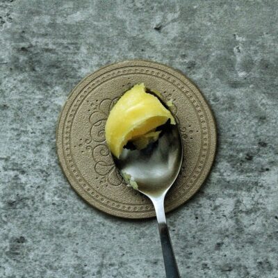 Ghee in solid form on a spoon.